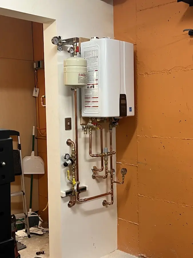 Plumbing technician inspecting water heater connections in Elm Springs